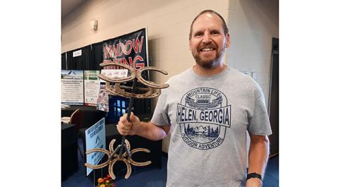 Bill Lombardo was happy with his purchase of a metal horseshoe cup holder made by Michael Spiropoulos of Young’s Fabrication in Hayesville during the eighth annual Northeast Georgia/Western North Carolina Home & Garden Show on July 23 at the Towns County Recreation & Conference Center in Young Harris, Ga. For details, see the July 27 edition of the Cherokee Scout, which was one of the sponsors.