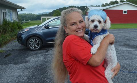 Jeanne Strack, founder of Puppies Under Construction, snuggles with newly adopted Jagger, a 9-year-old Bichon poodle, at a fundraiser for her Senior Scenter dog sanctuary.