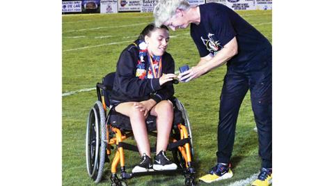 Murphy girls track and field head coach Penny Johnson gives Murphy’s Jordan Oliver her state championship ring at halftime of the Bulldogs’ football game against Franklin on Aug. 19. Oliver, a junior, won the 55-meter wheelchair dash at last year’s indoor track and field state championships as well as the 100-meter dash at the outdoor track and field state championships.