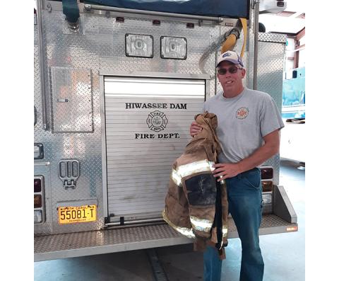 Anngee Quinones-Belian/Staff Correspondent Hiwassee Dam Fire Chief Chad McNabb holds some of the old turnout gear.