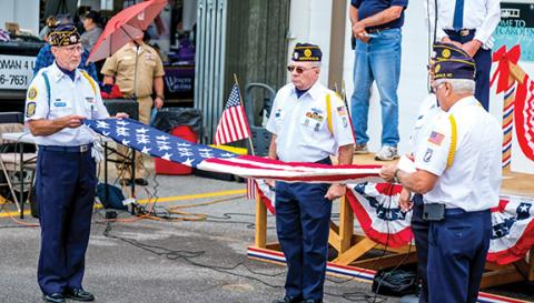 Sam Jokich/Staff Correspondent Dwight McClure and Philip Cantley of American Legion Post 532 show how to fold a U.S. flag, as Commander Joe Buckner explains why.