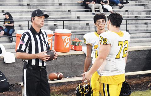 Justin Fitzgerald/sports@cherokeescout.com An official chats with Murphy captains Jeremiah Dickey (72) and Cameron Grooms (23) before the Bulldogs’ game against South Pittsburg, Tenn., on Friday night.