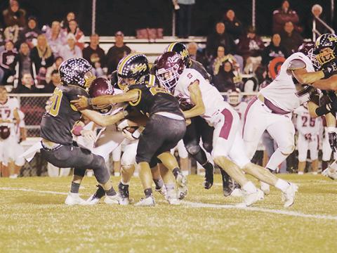 Dave Guffey/Contributing Photographer Murphy’s John Ledford (20) and Jonah Hedden (25) lead a group of Bulldogs trying to bring down the Swain County ball carrier during Murphy’s 20-14 win over the Maroon Devils on Friday night.