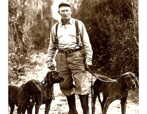 A vintage photo of Von Plott with a trio of his legendary Plott hounds.