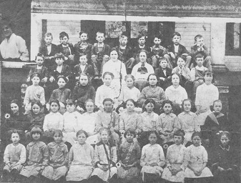 Miss Batten (inserted in the top left corner) taught this large fourth-grade class at Andrews School in 1914. There were 52 students who attended her classroom. The students are identified in the story.