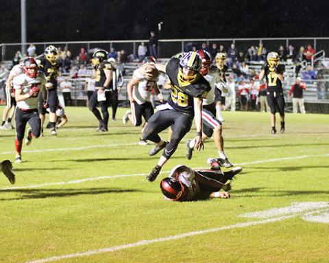 Dave Guffey/Contributing Photographer A Murphy offensive football player plows through the Mountain Island Charter defense during the Bulldogs’ 38-34 win in the second round of the state 1A playoffs Thursday night, as the game was moved up a day due to the weather forecast.