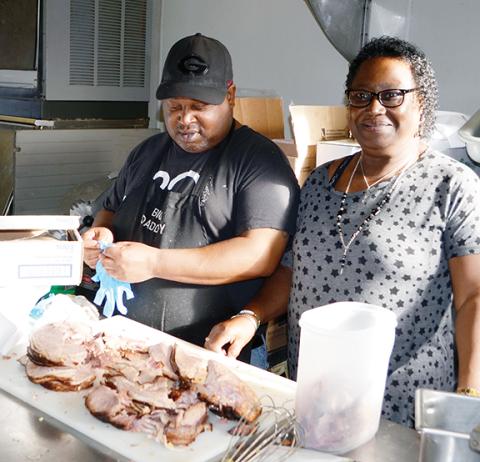 Abigail Blythe Batton/Staff Correspondent Annie Lloyd with her son, James Faulkner, help prepare food for the Rotary Club of Murphy’s free Thanksgiving dinner at Main Street Diner on Thursday morning.