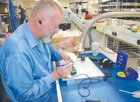 Photos by Abigail Blythe Batton/Staff Correspondent Bryan Holloway, a mechanical assembler for Aegis Power, concentrates on the details before the grand opening celebrating their manufacturing expansion Monday.