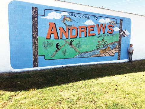 Photos by Abigail Blythe Batton/Staff Correspondent Artist Pamela Hopkins stands beside the mural she painted to help beautify downtown Andrews, where her family moved earlier this year.