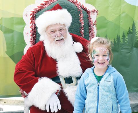 Bill Belian/Contributing Photographer   Lauren Baker of Hayesville was happy to see Santa Claus had come to Andrews for Christmas on Main Street.