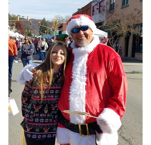 Anngee Quinones-Belian/Staff Correspondent  Andrews Mayor James Reid and daughter Remi enjoy being at Christmas on Main Street in Andrews last year.