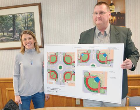 Abigail Blythe Batton/Staff Correspondent  Murphy Downtown Development Director Laura Lachance and Mayor Tim Radford (from left) display projections for the new roundabout at the four-way intersection, including the four pocket parks. Another view, 8A.