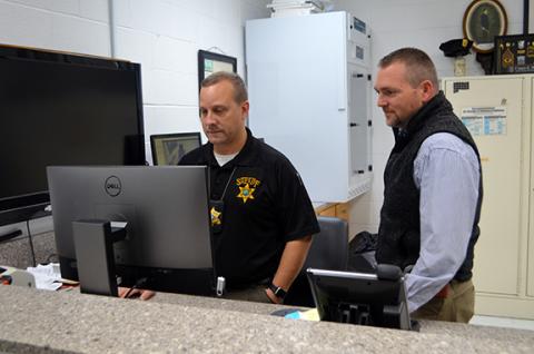 Abigail Blythe Batton/Staff Correspondent  Investigator Milton “Sport” Teasdale (left) and Sheriff Dustin Smith work in the evidence room at the Cherokee County Sheriff’s Office.