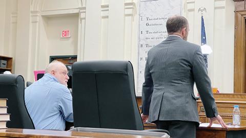  Randy Foster/editor@ cherokeescout.com  Murder defendant Bryan Crisp (left) sits while his lawyer, Bill Jones, talks with the judge last week at the Cherokee County Courthouse in Murphy.