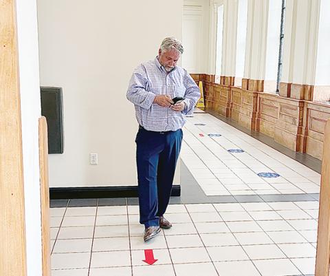 Randy Foster/editor@cherokeescout.com Andrews Mayor James Reid waits for District Court to start Thursday during his appearance on trespassing charges, which were dropped.