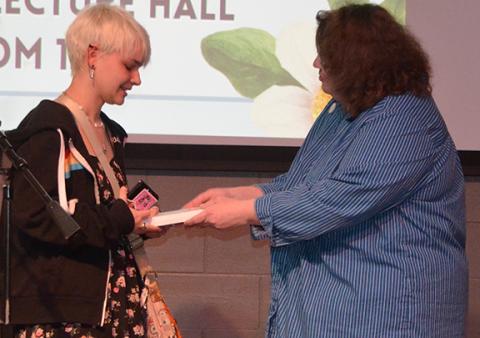 Abigail Blythe Batton/Staff Correspondent Lillian Graham receives an honorable mention from Kathy Temple during the April 6 poetry reading at Tri-County Community College.