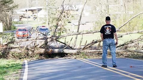 Photos by Randy Foster/editor@cherokeescout.com Firefighters from Valleytown Fire & Rescue stand by while waiting for Duke Energy workers to shut off power to a line taken down by a falling tree across Pisgah Road near Andrews on the afternoon of April 1.