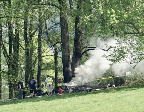 Emergency responders keep watch over the smoldering remains of a small airplane that crashed in Cherokee County, North Carolina, on Saturday, April 15.