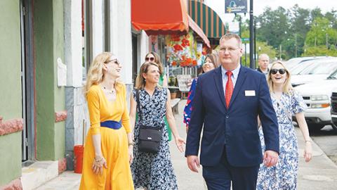 Randy Foster/editor@cherokeescout.com   Kristen Cooper (left) and Mayor Tim Radford lead an entourage while walking along Peachtree Street in downtown Murphy on Friday afternoon.