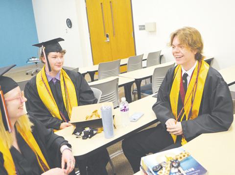 Photos by Abigail Blythe Batton/Staff Correspondent A summa cum laude and North Carolina academic scholar, Dylan Ritz, laughs with Early College classmates Antonio Vega and Braylee Miles-Anderson before their graduation at Tri-County Community College on Saturday.