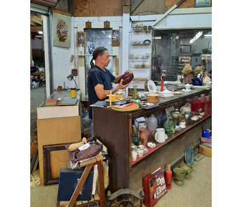 Photos by Anngee Quinones-Belian/Staff Correspondent  “Ponytail Mike” Asherbranner loved the flea market business and was good at finding items others could not. Last year, he was found examining an object in one of his shops at Decker’s Flea Market.