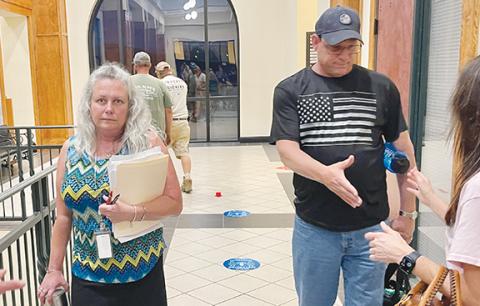 Randy Foster/editor@cherokeescout.com Teresa Ricks, with her husband David Ricks, greet well-wishers following a June 5 decision by the Cherokee County Board of Commissioners to keep her on as the county’s tax assessor.