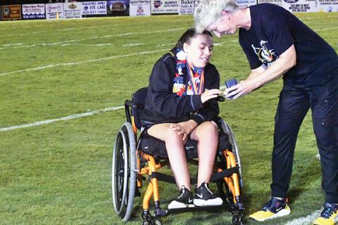 Justin Fitzgerald/sports@cherokeescout.com Murphy girls track and field coach Penny Johnson gives Jordan Oliver her state championship ring during halftime of the Bulldogs’ football game vs. Franklin in August. Johnson is retiring after 27 years as an educator and coach, including the last 17 at Murphy.