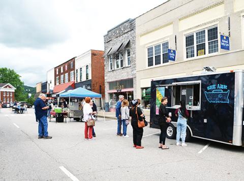Abigail Blythe Batton/Staff Correspondent Early birds line up to eat under menacing skies during the first Third Thursday event held in downtown Murphy on May 18.