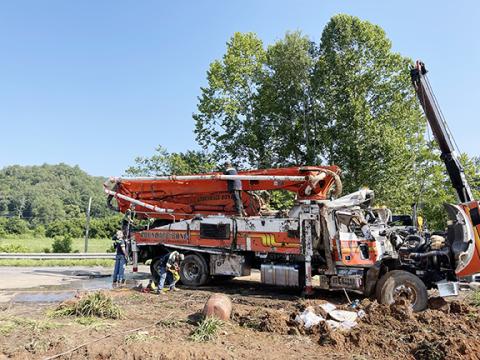 Photos by Randy Foster/editor@cherokeescout.com Wrecker operators disconnect lines from the wreckage of a concrete pumper truck that rolled over near Tomotla early Monday morning. 