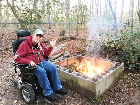 Photos by Becky Geyer/Contributing Writer Veteran Steve Geyer waves by his fire pit. He won a free roof for his house as a part of the Beacon of Hope Initiative, which provides a new roof for 10 veterans each year.