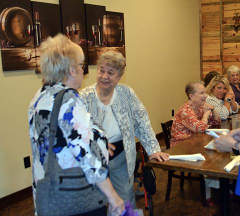Abigail Blythe Batton/Staff Correspondent Karen Borchers, executive director of the United Way, greets a guest during her retirement dinner at Legend’s Steakhouse in Murphy on Thursday night.