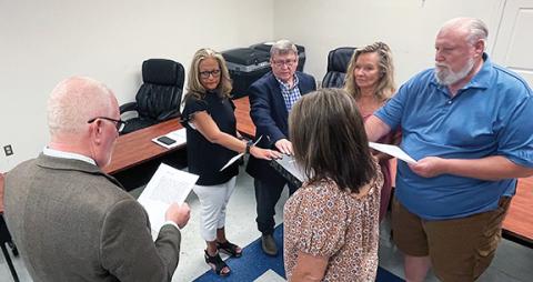 Photos by Randy Foster/editor@cherokeescout.com Clerk of Court Roger Gibson (left) administers the oath of office to board members as Director of Elections Leighsa Jones (foreground) holds a Bible at the Cherokee County Board of Elections office in downtown Murphy on July 18. Taking the oath are (from left) Shelley Debty, Craig Allen, Sandy Solesbee and Charles Hoesch.