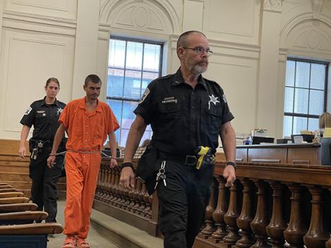 Randy Foster/editor@cherokeescout.com Patrick Ryan Williams, in an orange jail uniform, is escorted into court June 28.
