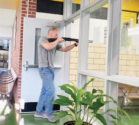 Randy Foster/editor@cherokeescout.com This is only a drill: Greg “Gunny” Chapman, administrative assistant/board liaison with Cherokee County Schools, wields a shotgun with blank rounds as he role-plays an active shooter during a drill at Murphy High School on Aug. 23.