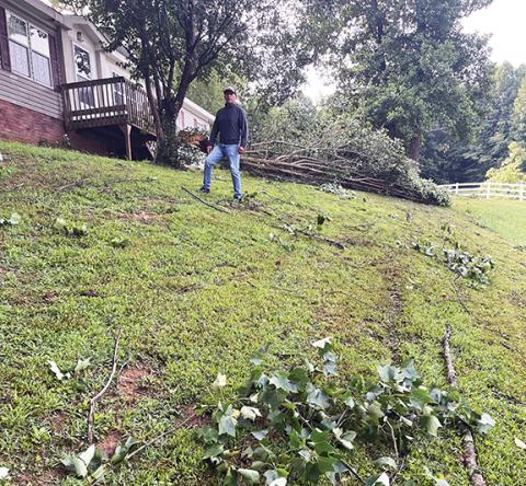 Randy Foster/editor@cherokeescout.com Cecelia Rosales Tinoco stands in his yard on the 1300 block of Fairview Road on Tuesday morning, taking stock of fallen branches and uprooted trees in his yard after a powerful storm swept through the area Monday.