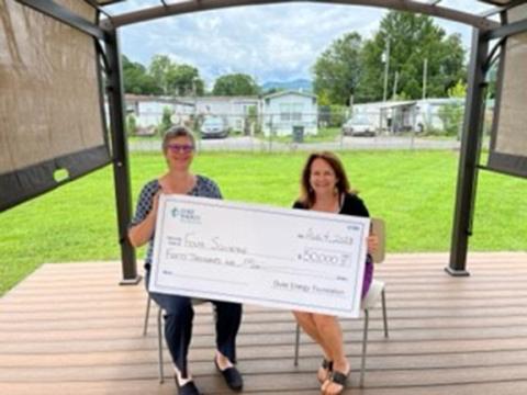 Lisa Leatherman (left), manager of government and community relations with Duke Energy, shows off the $50,000 grant award with Dr. Sue Lynn Ledford, executive director of Four Square Community Action.