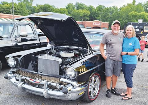 Photos by Bill Belian/Contributing Photographer Scott and Angie Dockery won a trophy for “Top 15” with their 1957 Chevy Bel Air. Happy to be at the Hot Summer Nights Cruise-in under rainy skies in Andrews, Scott said, “It takes five hours to wash, dry and shine it, but we’re happy to help the veterans.”
