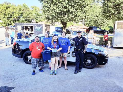 Photos by Anngee Quinones-Belian/Staff Correspondent  Four athletes who want to attend the N.C. Special Olympics in September helped raise money for the trip by selling stickers to cover a police car. The Murphy Police Department vehicle was poised at the L&N Depot on Thursday. From left are John Riley, Elizabeth Jennings, Lana Foster, Marian Carter and police Officer Justin Dockery. 