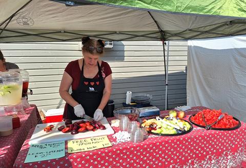 Photos by Anngee Quinones-Belian/Staff Correspondent  Nanette Davidson was helping promote nutrient-dense foods by offering fresh samples of a variety of fruits during Fun with Fruit Day at the Murphy Farmers Market on Aug. 19.