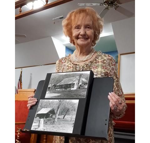 Photos by Anngee Quinones-Belian/Staff Correspondent  Kathleen Gibson-McGuire, a granddaughter of John Milton Anderson Jr., proudly holds up photos of the original family home during the 89th family reunion at Shady Grove Baptist Church in Ranger on Aug. 6. Read the article in the Aug. 30 edition of the Cherokee Scout.