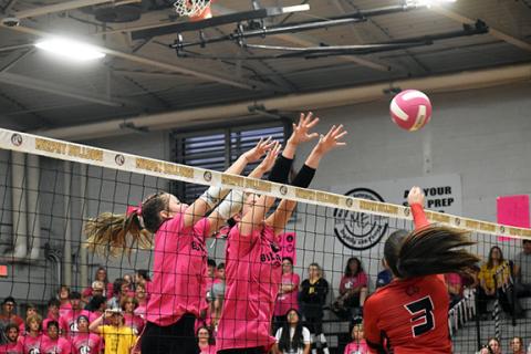 Justin Fitzgerald/sports@cherokeescout.com Andrews Madison Queen tries to hit the ball over the outstretched arms of Murphy’s Windsor Caldwell and Maddison Seabolt during the Lady Bulldogs’ 3-0 win over the Lady Wildcats on Thursday.