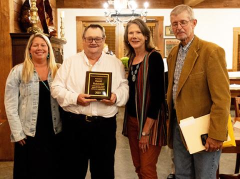 David Robinson (second from left) accepts a personal achievement award in recognition of his efforts in overcoming barriers to employment. Shown with Robinson are Emily Burch (left), employment specialist; and (at right) Lynne Manning, director of programs; and Dennis Myers, Vocational Resources services coordinator, all with IOI.