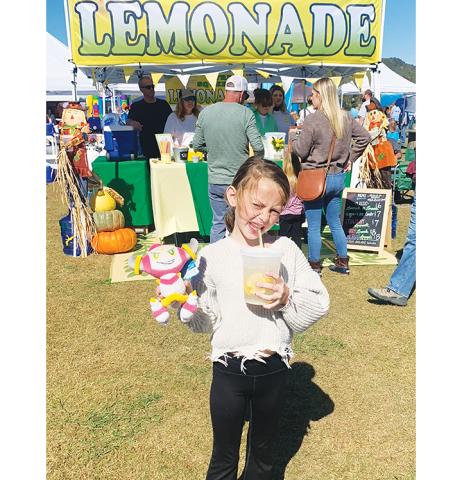 Photos by Gracie Taylor/Clay County Progress  Payton Taylor, 7, of Hayesville, enjoys a glass of fresh squeezed lemonade during the Punkin Chunkin on Oct. 21 in Brasstown. The annual event is sponsored by the Clay County Chamber of Commerce.