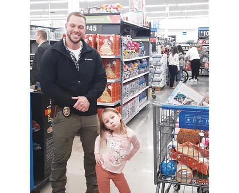 Photos by Anngee Quinones-Belian/Staff Correspondent Top: Andrews Police Chief Caleb Stiles partnered with the personable Tatum Lackey at Walmart on Saturday morning during the annual Shop with a Cop. He had to teach the youngster a lesson about spending after she loaded up her cart with items far exceeding the allotted dollar amount.