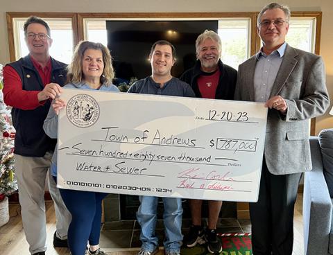 The real check for $787,000, which was distributed on Dec. 20, will come in handy as the Town of Andrews works to improve its water and sewer system. At left with the celebratory big check is state Sen. Kevin Corbin (R-Franklin), with state Rep. Karl Gillespie  (R-Franklin) at right. In the middle are Tammy Holloway and Ethan McCubbin with the town, along with Andrews Mayor James Reid. More than $11 million in state funding is earmarked for the town’s new treatment plant.