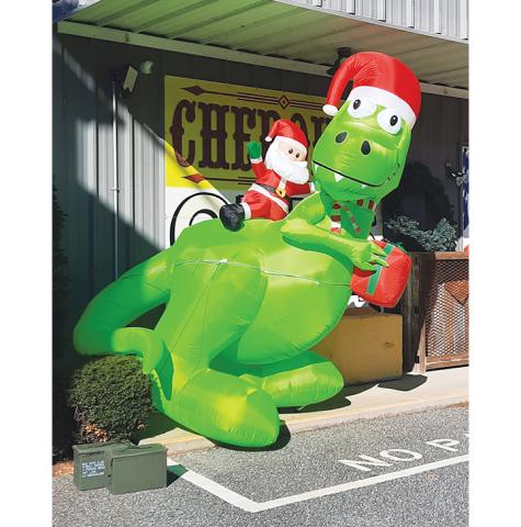Photos by Anngee Quinones-Belian/Staff Correspondent  Santa riding a dinosaur was seen stopping by Cherokee Guns on U.S. 64 West in Murphy.