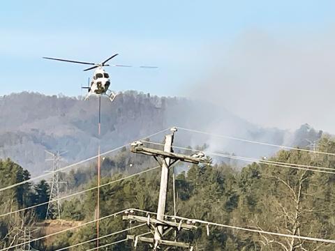 Randy Foster/editor@cherokeescout.com A helicopter dips its bucket into the Valley River on Feb. 7 while deployed to the Bonnie Brae Incident northwest of Western Carolina Regional Airport in Andrews.