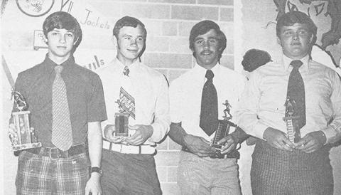 Football coach Gene Young presents four students with trophies (from left) Randy Mason, Donnie Bradley, Danny Hawk and Mike West.
