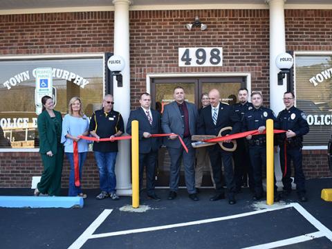 Bill Belian/Contributing Photographer  The Cherokee County Chamber of Commerce held a ribbon-cutting ceremony for the new Murphy Police Department building Thursday at 498 Hill St. From left are Victoria Ivie (Cherokee County Chamber of Commerce executive director); town council members Cindy Chastain and Barry McClure; Investigator Jason Murphy, Assistant Chief Ryan Cunningham, BLET student Sara Taylor, Cpl. Hunter Sanders, Patrol Officer Parker Southard and Sgt. Adam May, with Chief Tim Lominac in the cen