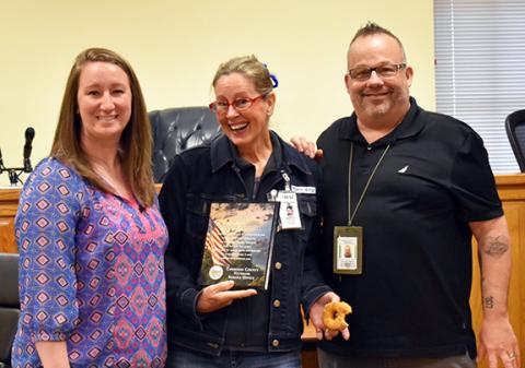 Bill Belian/Contributing Photographer Danna Pash, director of Cherokee County Veteran Services, and Richard Millett, veteran services officer, present Cherokee Scout Staff Correspondent Anngee Quinones-Belian (middle) with a plaque of appreciation on April 10 for her love and support of the county’s veterans.